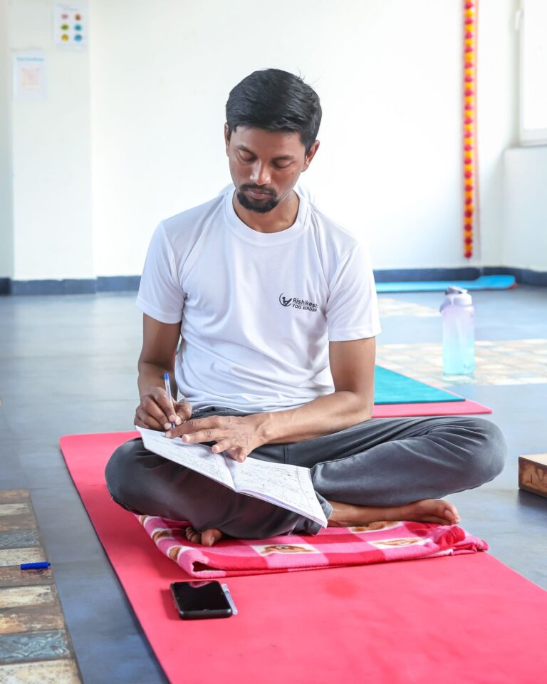 Yoga practitioner writing in a journal during self-study