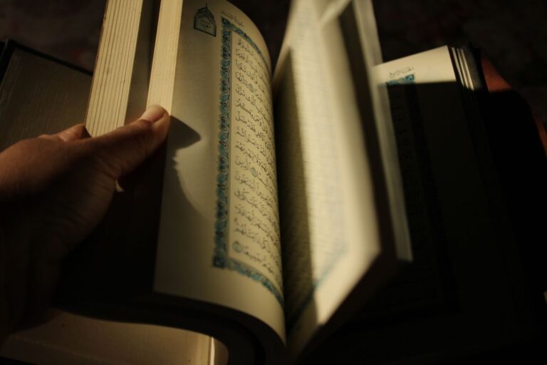 Hand turning pages of a religious text during quiet study