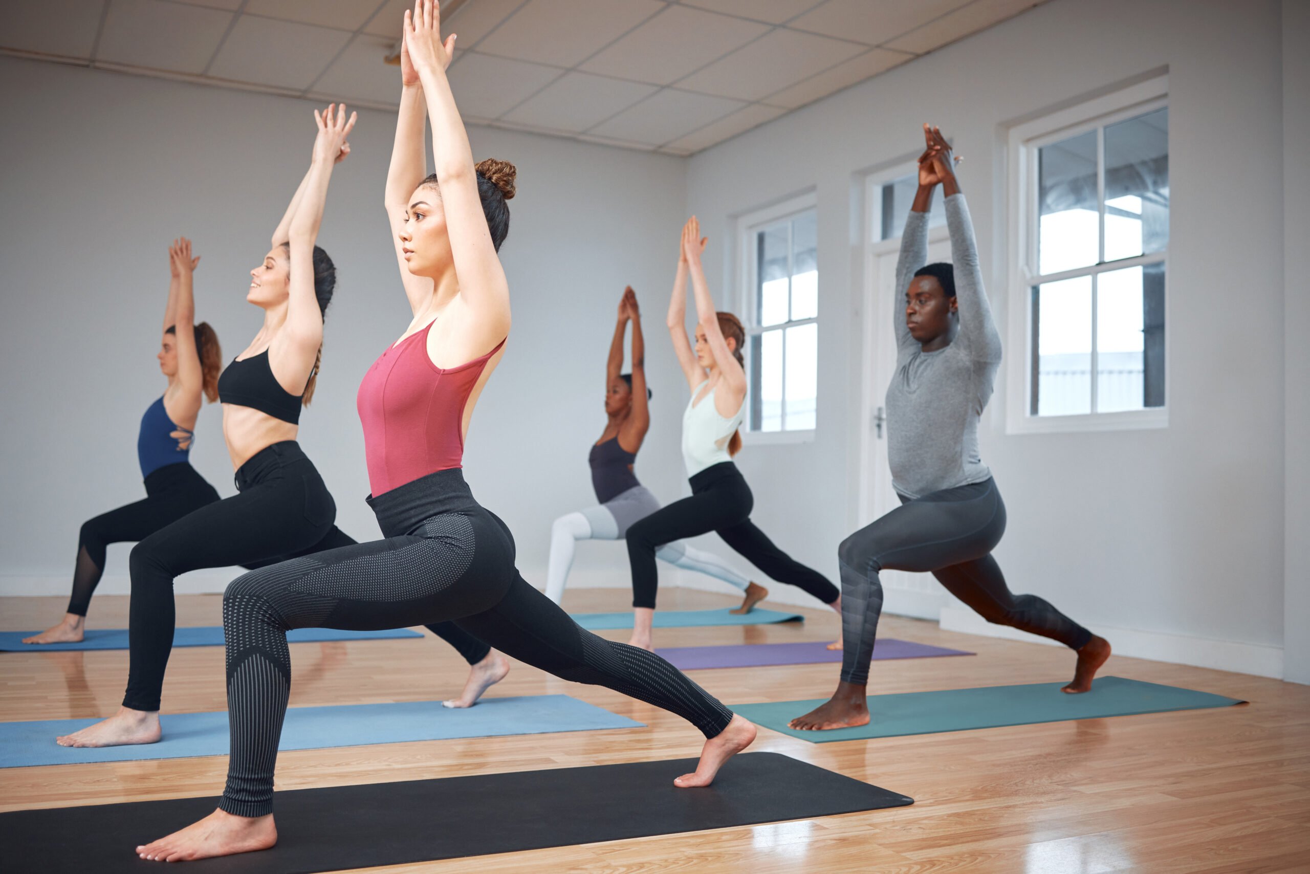 Small group practicing yoga together in a bright indoor studio