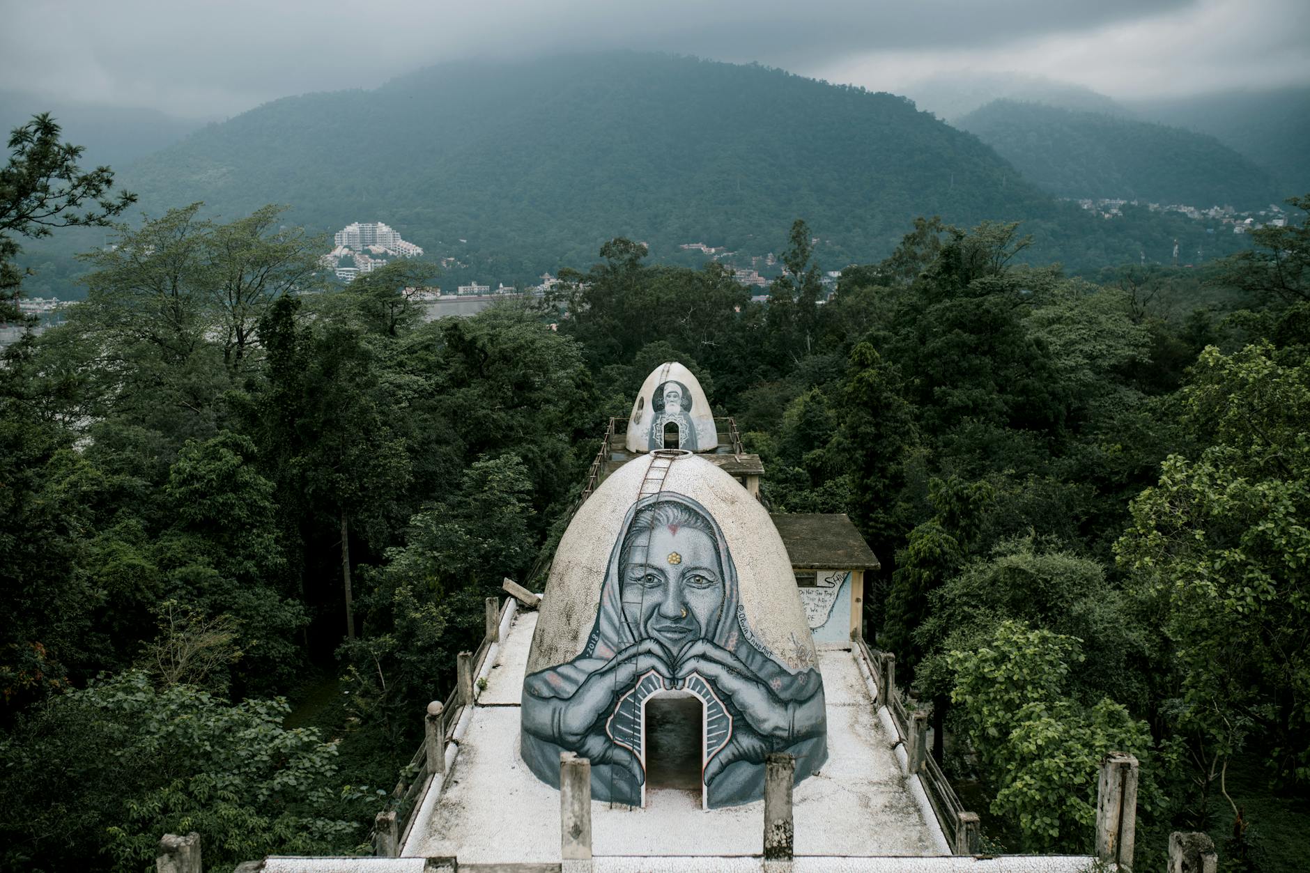 rooftop meditation dome surrounded by lush green trees in mountains