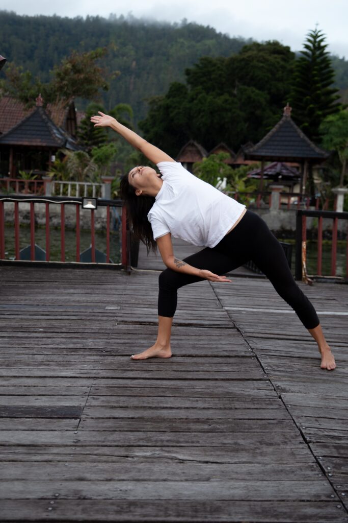 Woman practicing yoga outdoors at sunrise