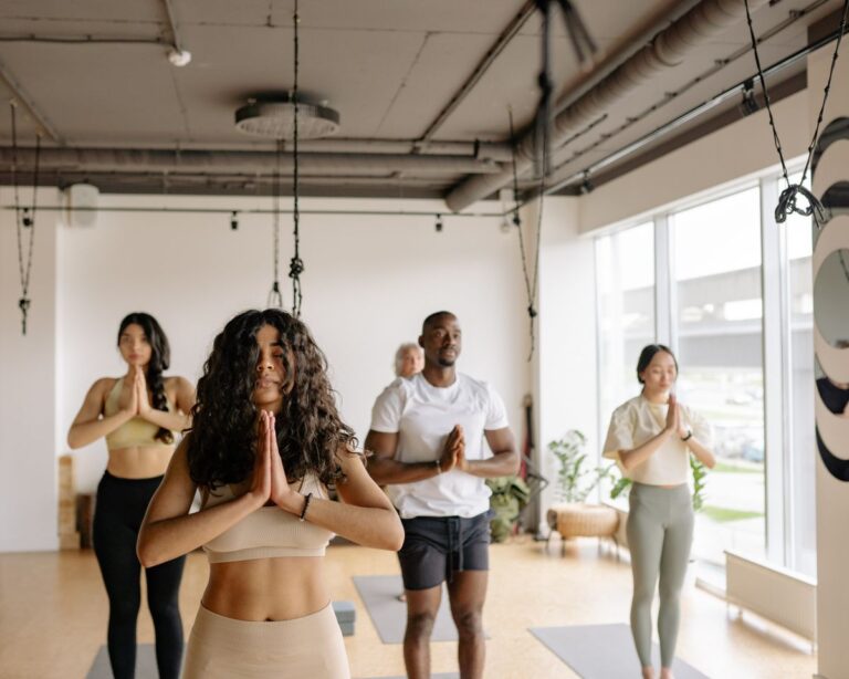 Adults practising yoga together in a bright studio