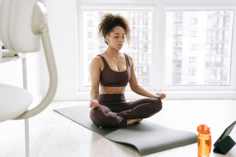 Woman practising yoga at home on a mat during a regular weekly routine