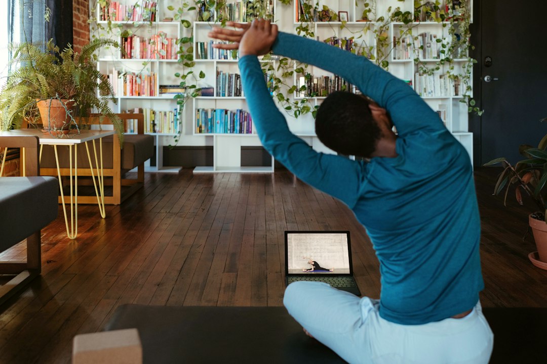 Person following yoga practice at home with technology
