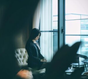 Woman sitting quietly in a chair near a window
