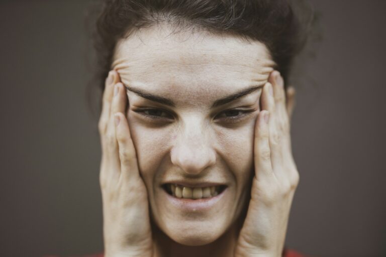 Woman touching both sides of her face with her hands
