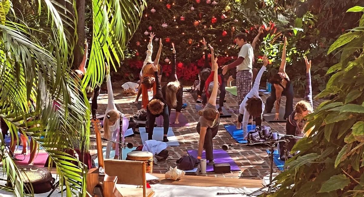 People practising yoga on mats in an outdoor garden, from the St. Pete Yoga Fest gallery